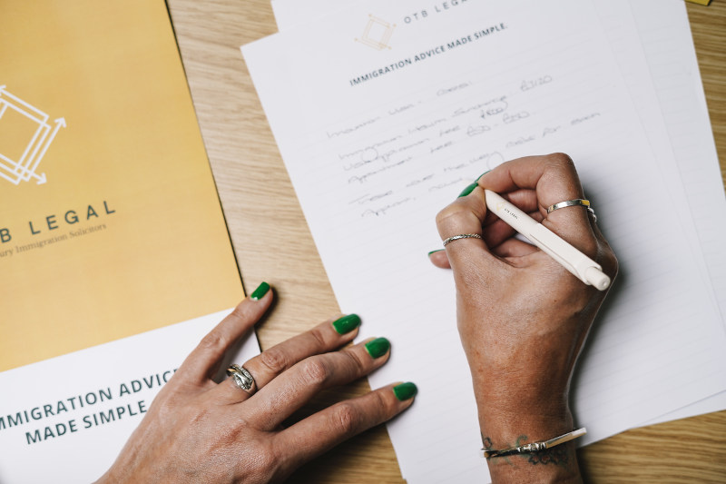 Female hands writing a document on OTB Branded paper