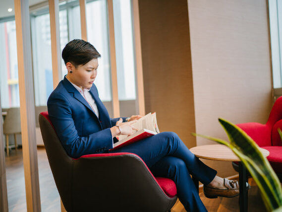 Business Person Sat On Chair With A Book