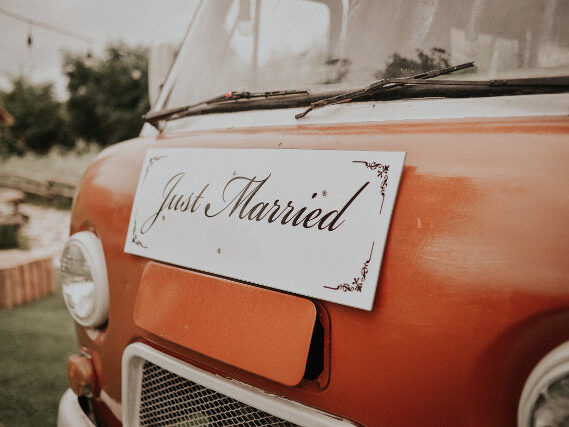 Just Married Sign On Front Of Small Car