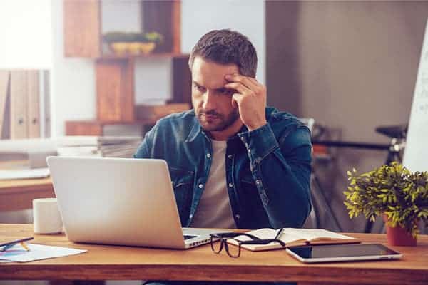 Man Sat At Laptop Thinking