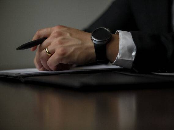 Abogado con reloj inteligente sosteniendo un bolígrafo