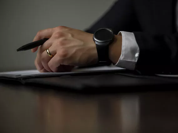 Advogado com smartwatch segurando caneta