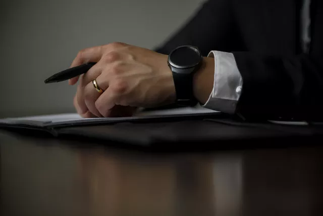 Avocat avec une montre connectée et un stylo
