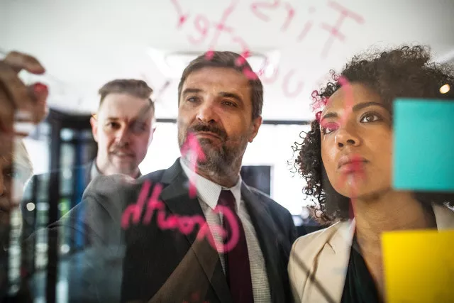 Trois collègues font un brainstorming autour d'un tableau