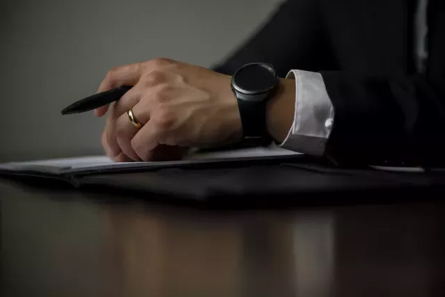 Avocat avec une montre connectée et un stylo