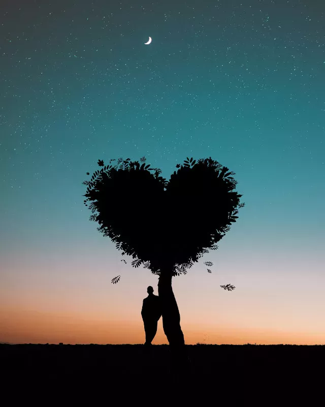 De pie solo bajo un árbol con forma de corazón