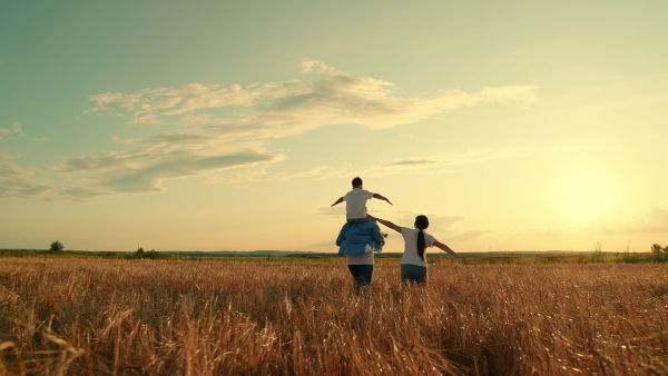 Family Running Through Field Together