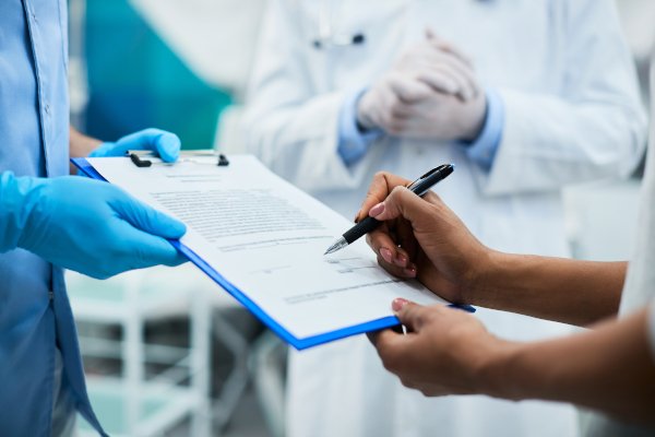 Médico e paciente preenchendo a documentação