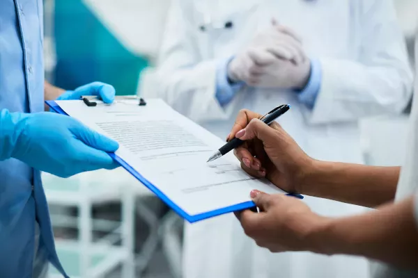Médico e paciente preenchendo a documentação