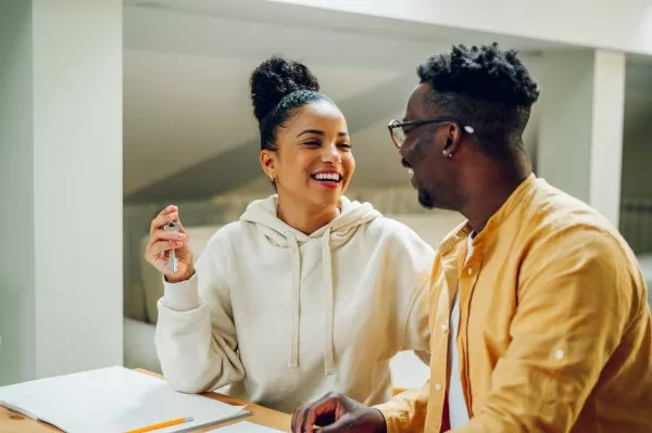 Un couple heureux à table avec des clés