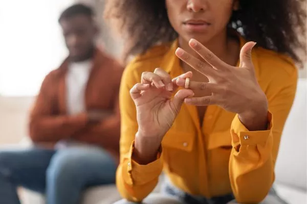 Una mujer se quita el anillo de bodas. Solicita un visado de cónyuge para el Reino Unido tras el divorcio