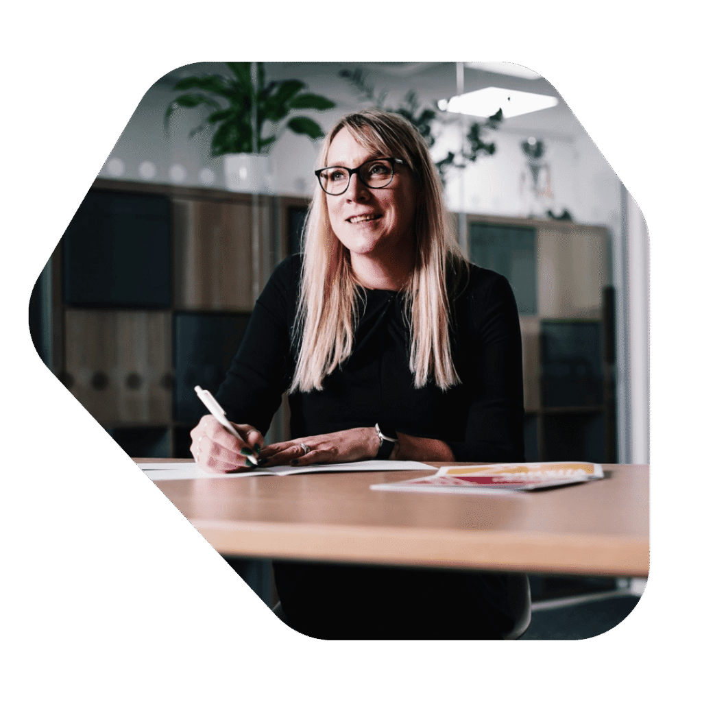Immigration Lawyer Wokingham at desk smiling and writing