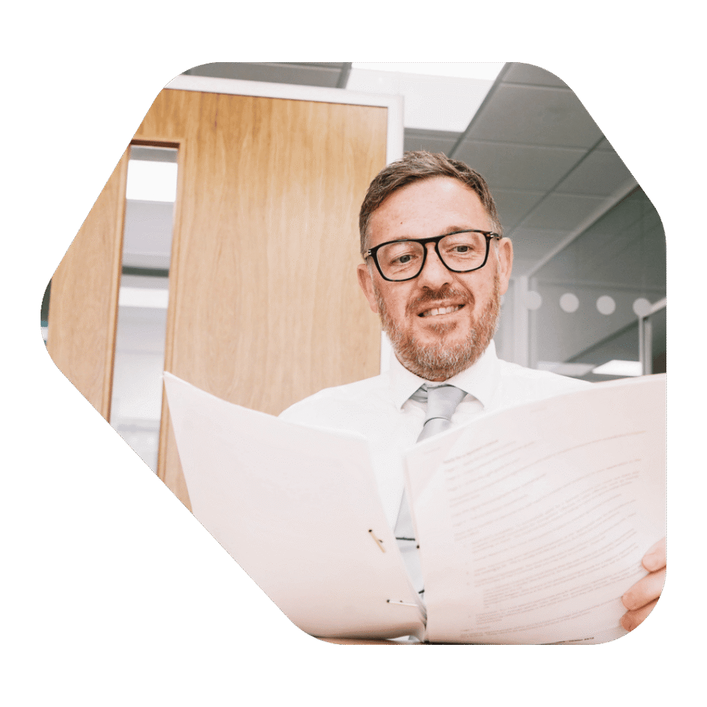 Immigration Lawyer Chichester reading a document and smiling at desk